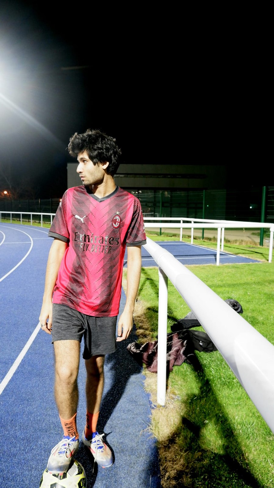 Playing five-a-side football at night in an AC Milan kit